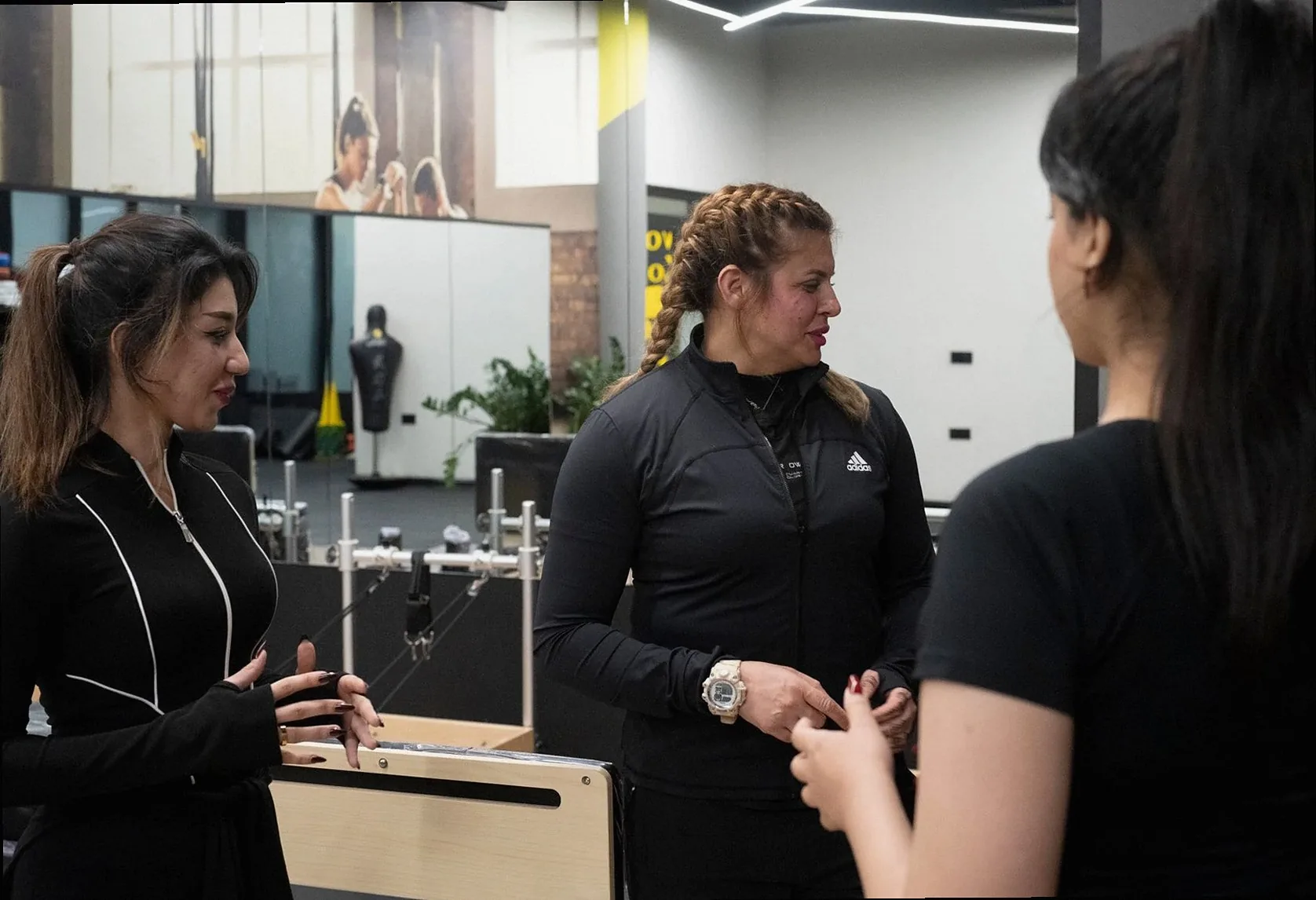 Coach talking through a movement with two members
